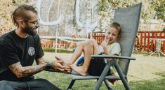 Playful interaction between a father and son in a sunny backyard setting.