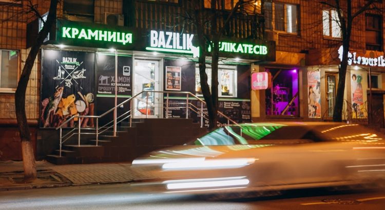 cars parked in front of store during night time